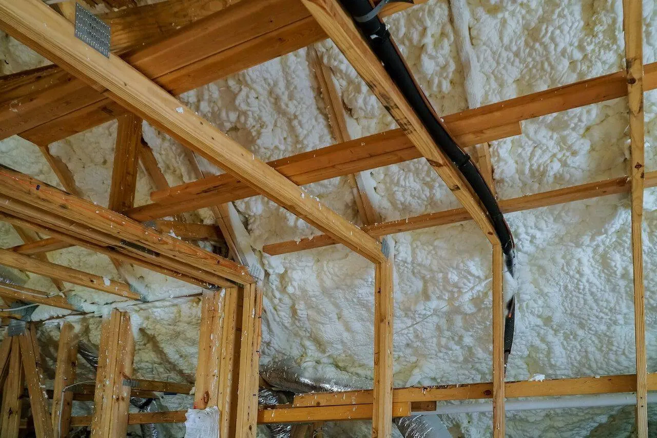 Attic framing with fresh spray foam coverage